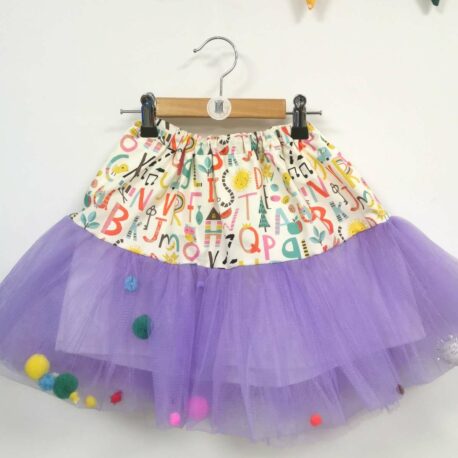 tutu en tulle violet avec un imprimé alphabet multicolore au niveau de la taille